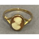A George V shell cameo ring in 9ct gold, the oval female portrait collet set flanked by bifocated
