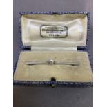 A cultured pearl set bar brooch c.1935 in a 9ct white gold, the tapered bar set to the centre with a