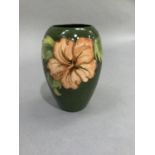 A Moorcroft pottery vase of ovoid shape, tube lined and glazed in coral and green wiith hibiscus,