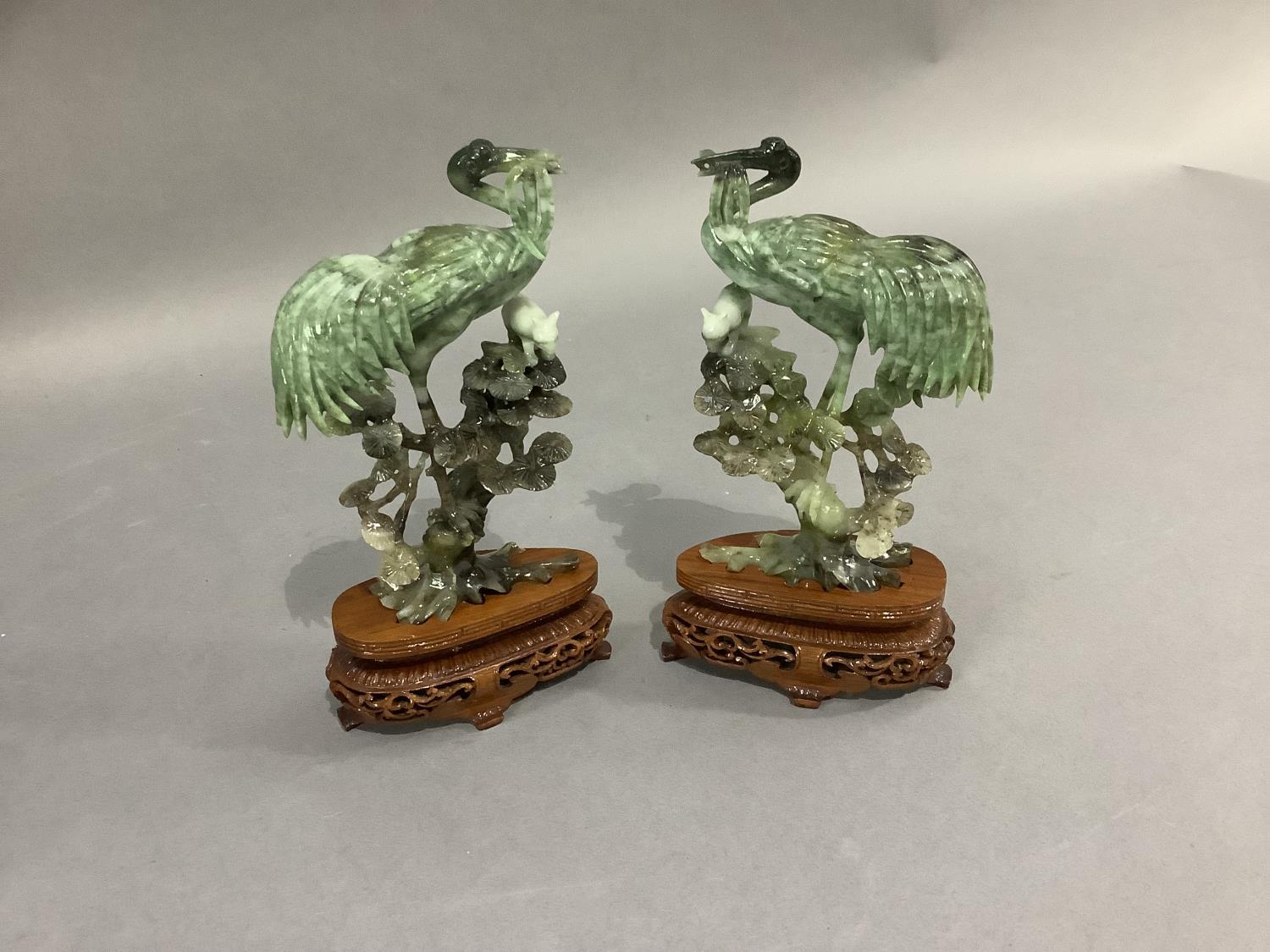 A pair of Chinese polished hardstone figures of an egret and cat in the branches of a pine tree,