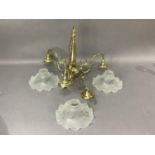 A brass three branch chandelier, the frilled opaque glass shades acid etched with vine leaves and