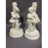 A pair of figural Copeland china candlesticks modelled as winter and autumn, 29cm high, restored