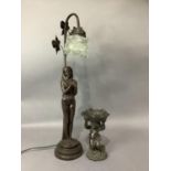 A bronze effect figural table lamp together with a cherub holding a petal bowl above