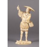 A fine Japanese Ivory okimono of a fisherman, standing on a rock, a fishing net pegged down in the