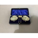 A pair of silver shell salts and matching spoons in a leather velvet lined case