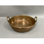 A copper two handled pan, 45cm diameter over handles by 15.5cm high