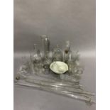 A collection of laboratory glassware including flasks, measures, test tubes, bottles and ceramic