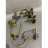 A pair of Edwardian brass wall lights of scrolled form and two further wall lights of similar