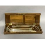 An Edward VII mahogany cased set of medical instruments, London 1906, comprising of ten Proximal