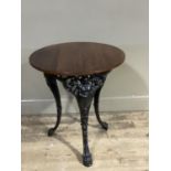 A Victorian style cast iron pub table with circular oak top on a pierced frame with Britannia and