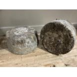 Two stone blocks of circular outline, 23cm high by 43cm diameter, 28cm high by 42cm diameter