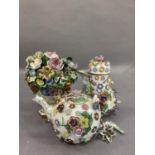 An early 19th century Derby flower cluster held in an urn with face mask decoration to the rim, on