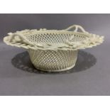 A Belleek china basket, the rim with applied twin handles and sprays of flowers, 20.5cm diameter,