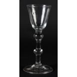 A MID 18TH CENTURY WINE GLASS with a small rounded funnel bowl on double knopped stem and folded