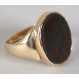 A GEORGE V BLOODSTONE SIGNET RING IN 9CT GOLD, the oval plain seal collet set in a closed back