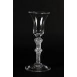 A MID 18TH CENTURY WINE GLASS with bell bowl on a double knot air twist stem on a conical foot, 16cm