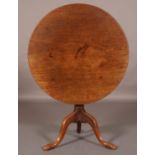 A GEORGE III MAHOGANY TILT TOP TABLE, circular, on a vase turned column and three cabriole legs with