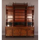 AN ARTS & CRAFTS WALNUT BOOKCASE-CUPBOARD, the breakfront upper section having a railed and