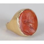 A LATE VICTORIAN CORNELIAN INTAGLIO SIGNET RING IN 9CT GOLD, the oval stone collet set, incised with