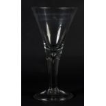 A MID 18TH CENTURY GLASS GOBLET with drawn funnel bowl, on a tear drop stem and folded circular