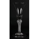 A MID 18TH CENTURY WINE GLASS with bell bowl, on an air twist stem with shoulder knop, on a folded