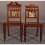 TWO LATE 19TH CENTURY WALNUT HALL CHAIRS on turned legs, each inset to the back with a tile