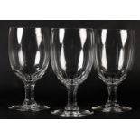 A SET OF THREE LARGE GLASS GOBLETS, the ovoid bowl slice cut to the base and stem on conical foot,