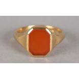 A VICTORIAN CORNELIAN SET SIGNET RING in 18ct gold, the octagonal plain stone collet set, flanked by