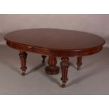 AN EARLY VICTORIAN MAHOGANY EXTENDING DINING TABLE, of oval outline, on four lobed legs, each carved