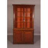 A VICTORIAN MAHOGANY BOOKCASE-CUPBOARD, having a moulded cornice above two glazed doors, the