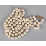 A CULTURED PEARL NECKLACE, the approximate 7.5mm baroque pearls fasted with a 14ct gold snap,