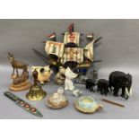 Carved elephants, mountain goats, other animal figures, brass table bell and a galleon ornament