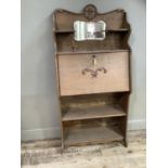 A late Victorian oak bureau bookcase having a raised top with inset mirror and two shelves above a