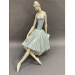 A Lladro figure of a ballerina sitting upon a stone plinth, 35.5cm high