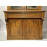 A Victorian walnut bookcase-cupboard having a moulded cornice above two glazed doors, frieze