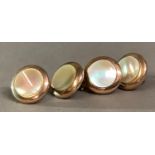 A set of four mother of pearl dress shirt studs in rolled gold and base metal