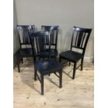 A set of modern ebonized dining chairs with vertical railed backs