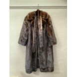 A mink coat with slit pockets and tie belt