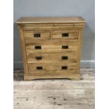 A modern oak chest of two short and three long drawers with swing handles on bracket feet