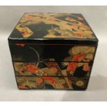 A modern Japanese three tier lacquered box and cover of square outline, printed in gilt and iron red