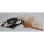 A circa 1900 -1910 black wood fan, the monture clouté with steel, the upper guard carved and