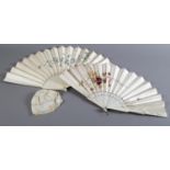 Two large late 19th century bone fans, each with a cream leaf, the first well painted on silk