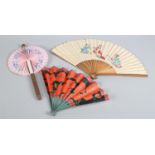 A novelty cigar fan, A pink paper cockade fan with blue floral pattern contained in a tube