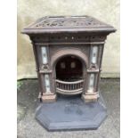 A Victorian cast iron stove inset with tiles in pale grey, brown on white, the design of