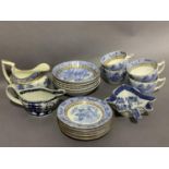 A quantity of early 19th century blue and white willow pattern tea ware highlighted in gilt
