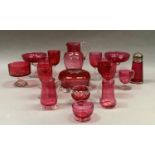 A collection of cranberry glass including pedestal dishes, six various wines, jug, powder bowl and