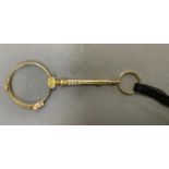Early 20th century lorgnette in 14ct gold, the circular lenses on scroll pierced stem with pendant