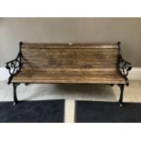 A new garden seat with wooden slats and cast iron scrolled end panels, 163cm wide