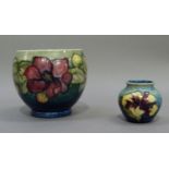 A Moorcroft vase, tube lined and painted with clematis together with a smaller vase with hibiscus,