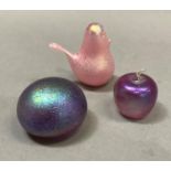 A Glasform English handmade iridescent glass apple, a similar Glasform paperweight and a pale pink